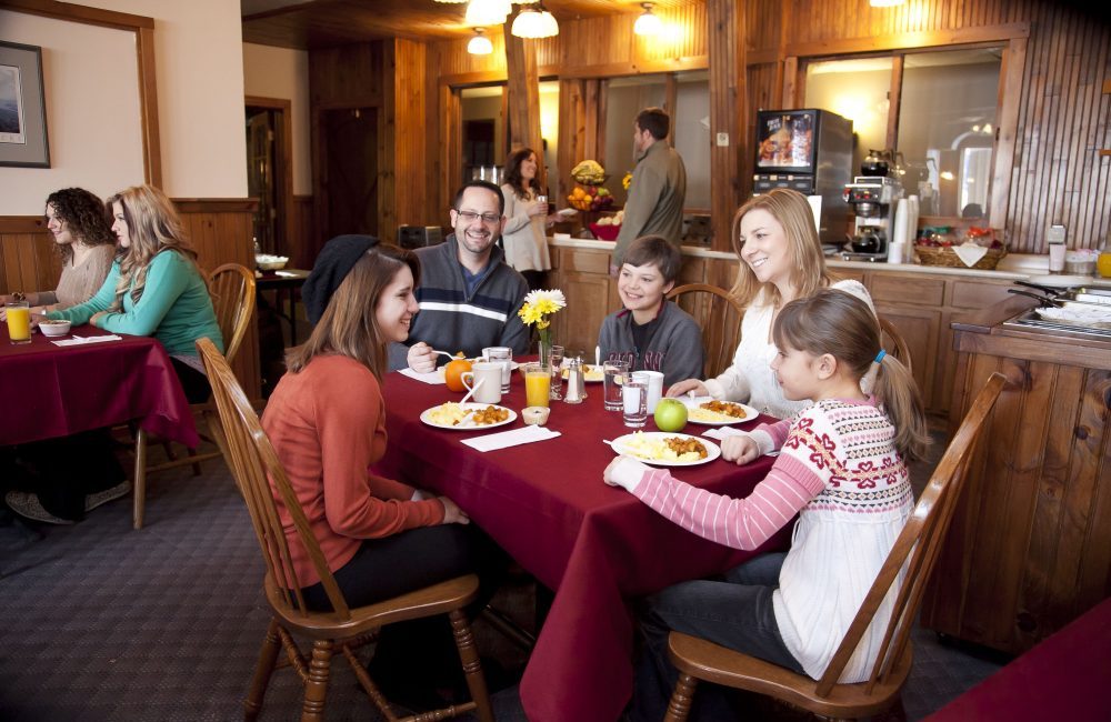 A family smiling sitting around a table at a restaurant