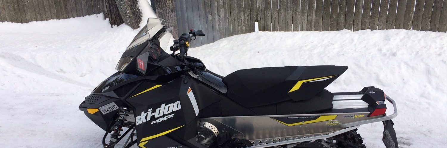 A ski-doo snowmobile parked in the snow