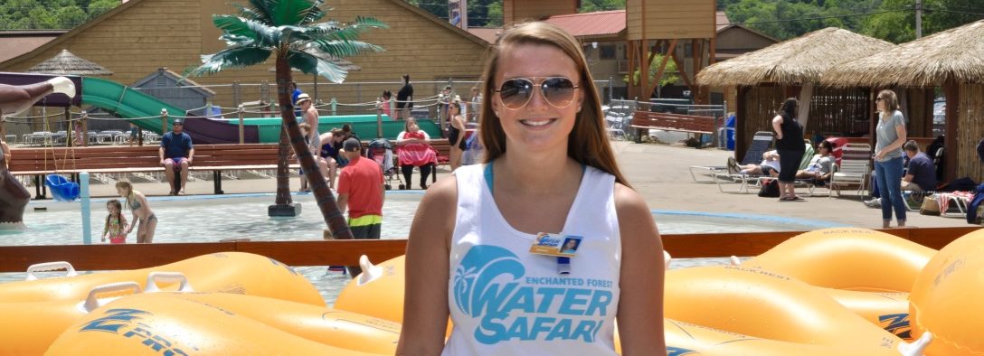 Female employee standing near the kids water area smiling.