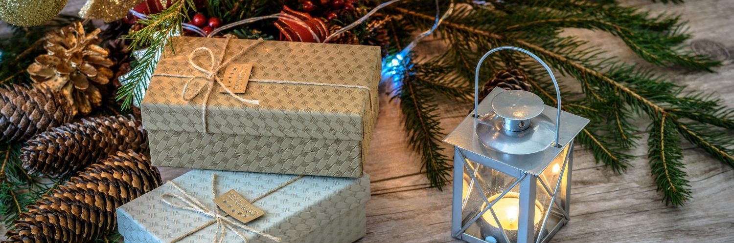 Shot on cartons decorated with string and label on a wooden table under Christmas tree with cones