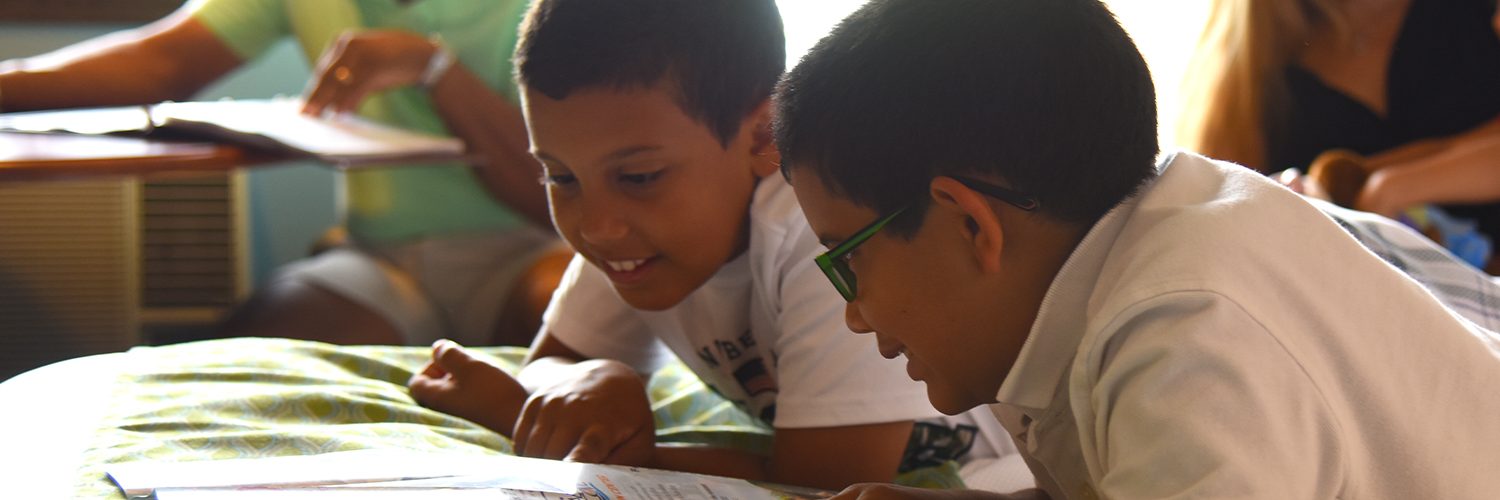 Two boys smiling and reading