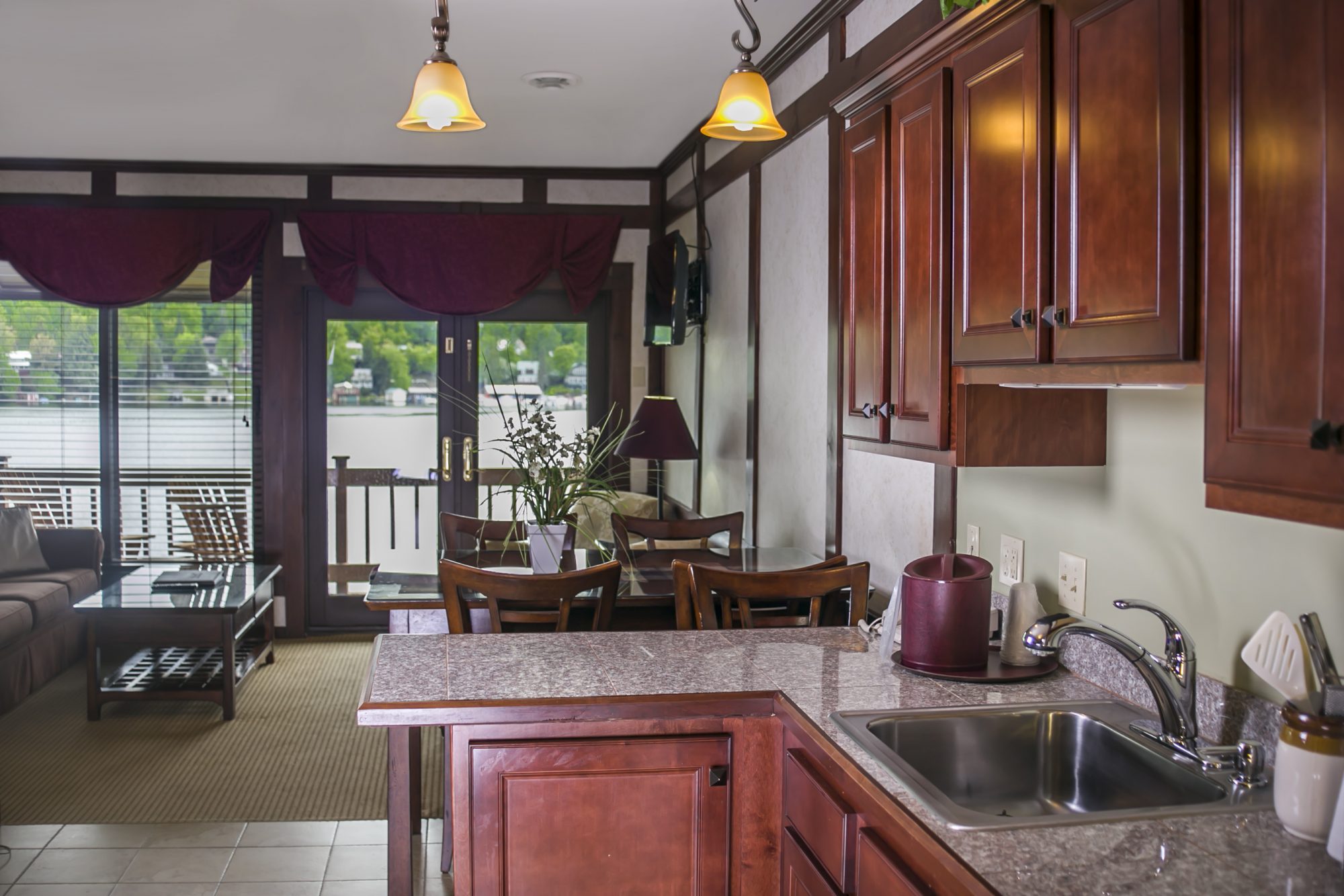 View from a kitchen looking into a living room with a porch that has a view of the lake