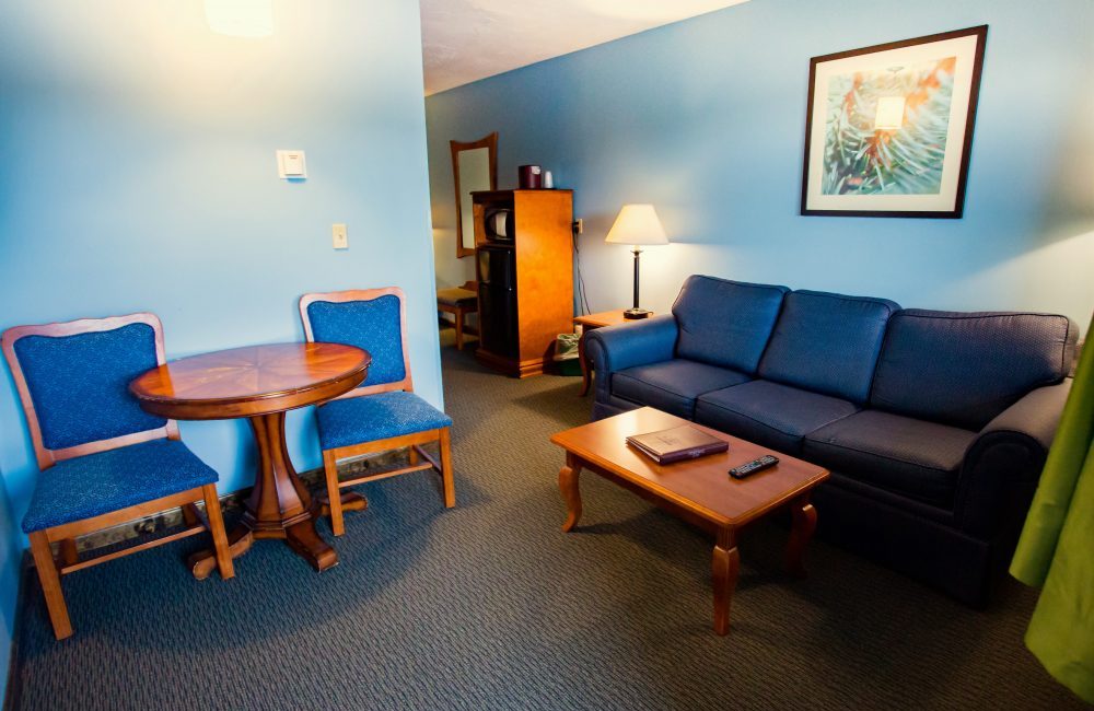 A living room with a couch, coffee table, and a small table with two chairs