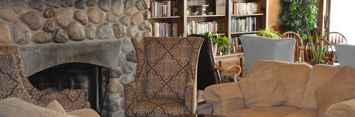 Couches and chairs set up around s stone fireplace