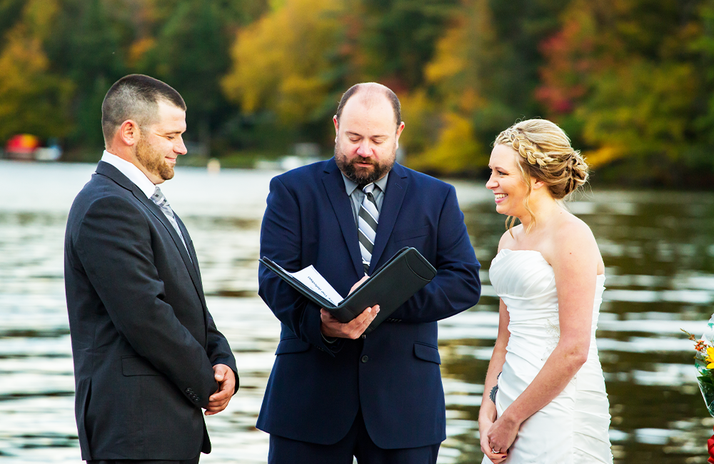 people getting married in front of the lake in the fall